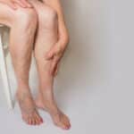 The varicose veins on a legs of old woman on gray