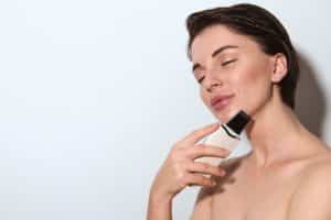 Caucasian elegant woman with pleasure treating skin with beauty device for peeling